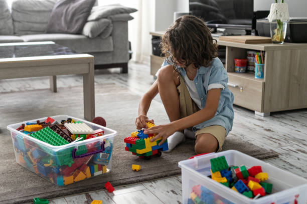 istock Little toddler boy playing with colorful plastic blocks at home building creative game, imagination 1408022802