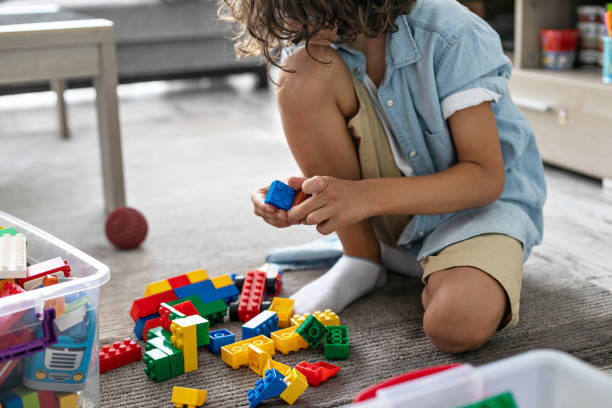 istock Little toddler boy playing with colorful plastic blocks at home building creative game, imagination 1408022811