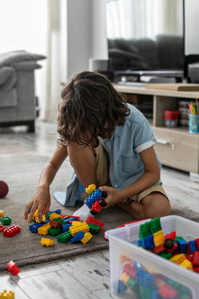 istock Little toddler boy playing with colorful plastic blocks at home building creative game, imagination 1408022944