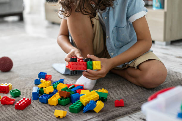 istock Little toddler boy playing with colorful plastic blocks at home building creative game, imagination 1408022945
