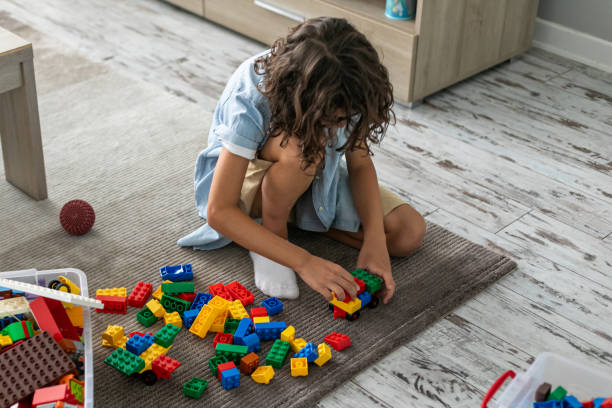 istock Little toddler boy playing with colorful plastic blocks at home building creative game, imagination 1408022963