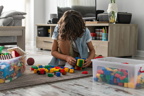 istock Little toddler boy playing with colorful plastic blocks at home building creative game, imagination 1408023039