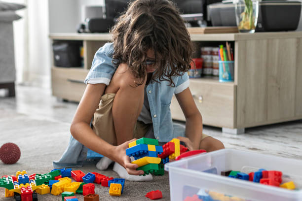istock Little toddler boy playing with colorful plastic blocks at home building creative game, imagination 1408023048
