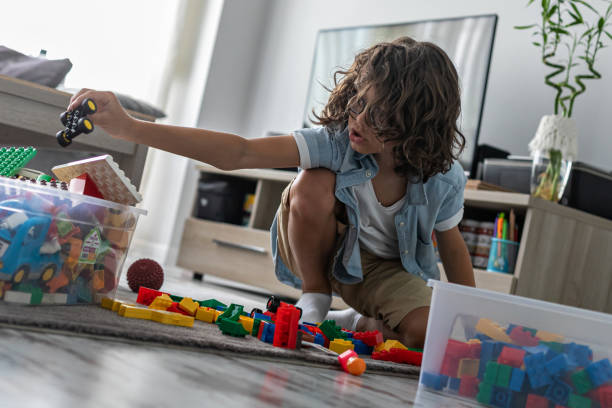 istock Little toddler boy playing with colorful plastic blocks at home building creative game, imagination 1408023075