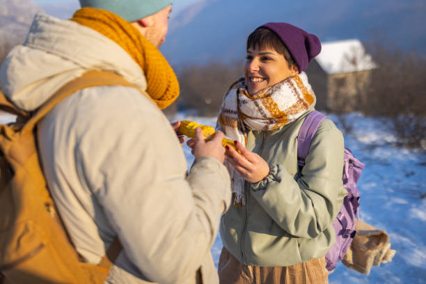 istock Young Caucasian couple, eating corn, while taking break from their hike 1408025935