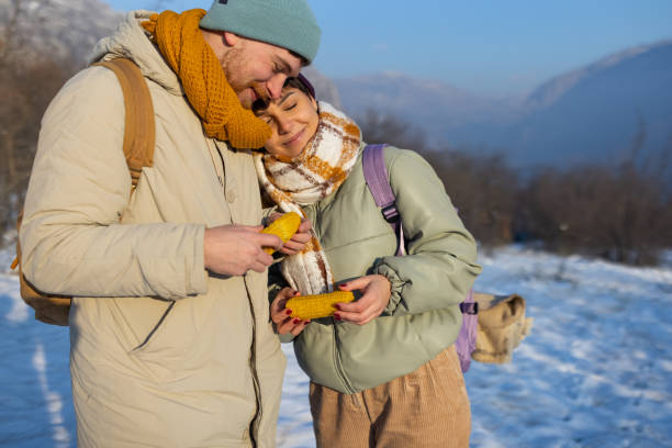 istock Young Caucasian couple, eating corn, while taking break from their hike 1408026171