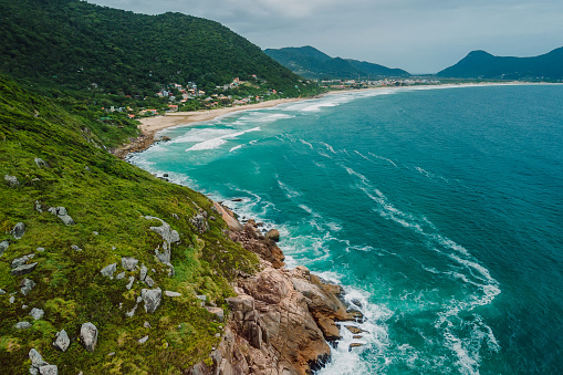 Scenic coastline with mountains and blue ocean with waves in Brasil. Aerial view