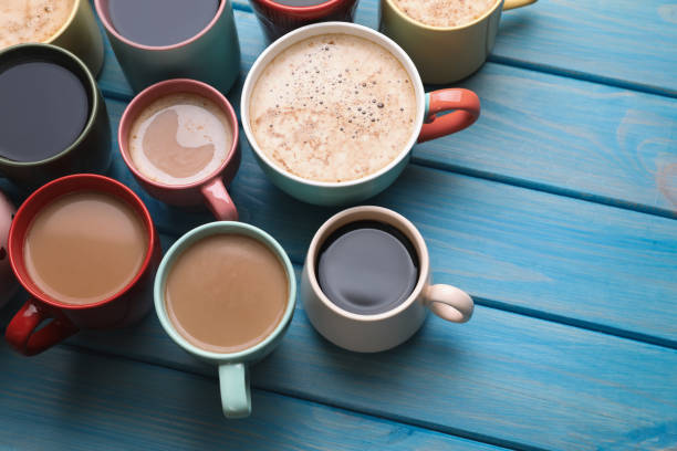 istock Many cups of different coffee drinks on light blue wooden table, above view 1408029666