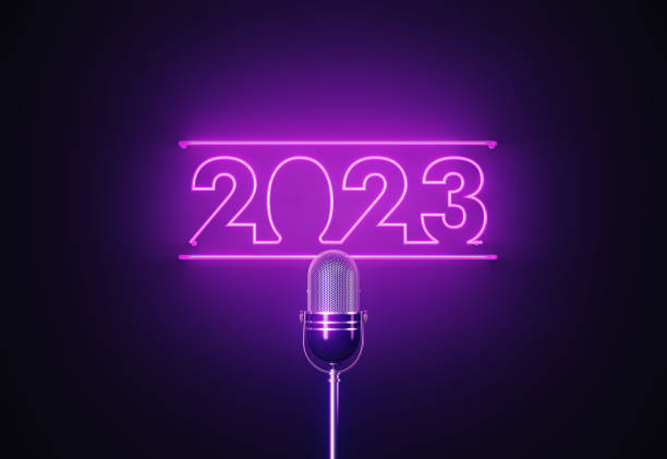 фиолетовый неоновый свет пишет 2023 над серебристым микрофоном на черном фоне - best in show стоковые фото и изображения
