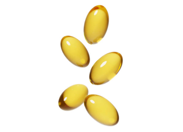 goldfarbene pillen auf weißem hintergrund - fish oil cod liver oil pill omega3 stock-fotos und bilder