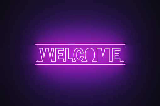 Purple neon light writes welcome on black background. Horizontal composition with copy space.