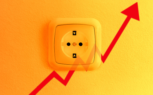 Red chart arrow pointing up over an electrical outlet. Concept for: energy efficiency, electricity consumption, rising electricity prices, and energy concept