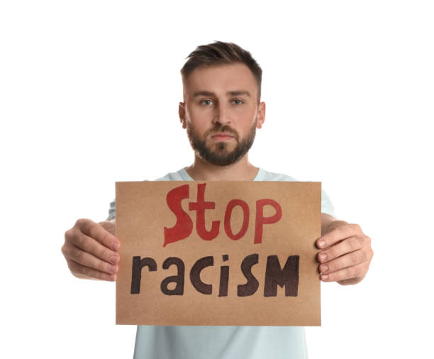 istock Young man holding sign with phrase Stop Racism on white background 1408034632