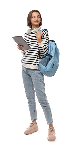 Young student with tablet, backpack and headphones on white background