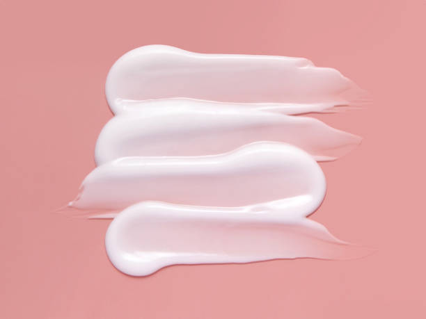 White cosmetic cream lotion swatch smear smudge on pink background. stock photo