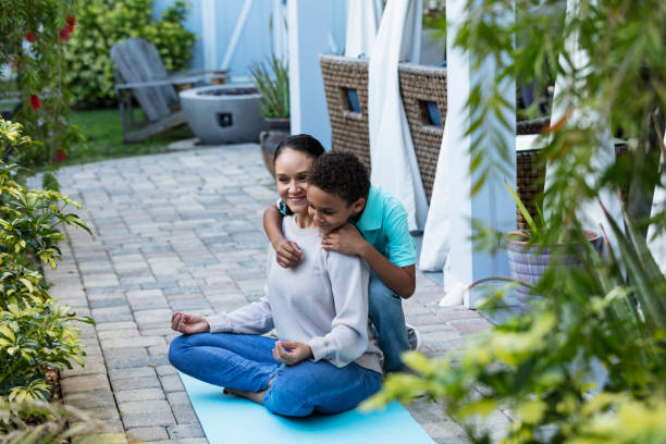istock Mother smiling, meditation interrupted by hug from son 1408038633