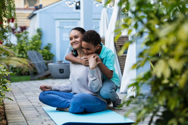 Mother smiling, meditation interrupted by hug from son