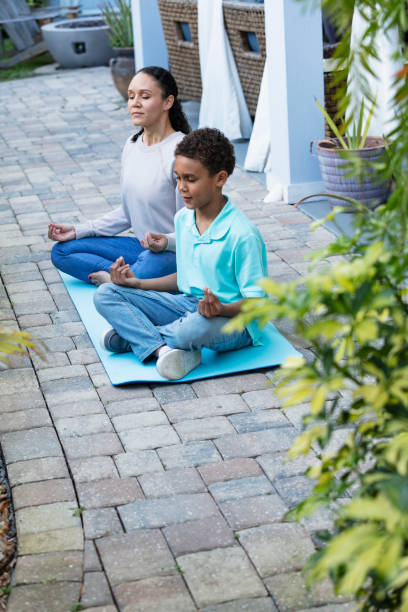 istock Multiracial mother and son meditating together on patio 1408038708