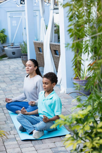 istock Multiracial mother and son meditating together on patio 1408038740