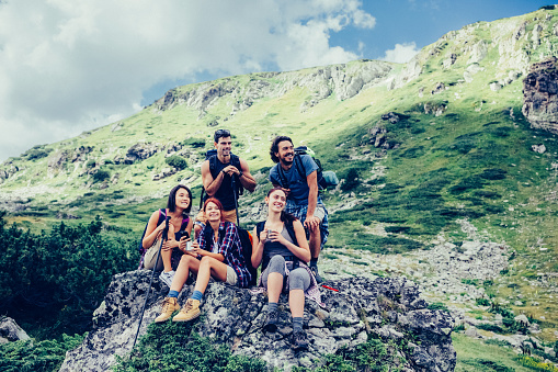 Young people in the mountain resting on stone