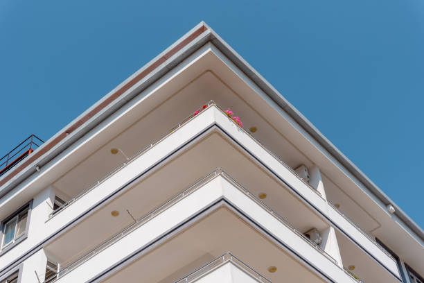 Bottom view of a corner of a modern building with balconies.