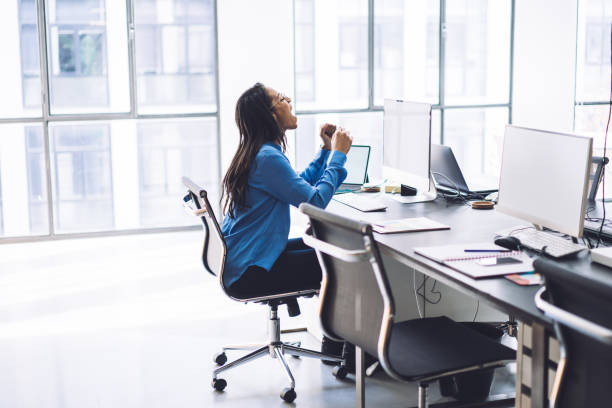 istock Happy elegant ethnic female screaming while sitting at computer in office 1408041078