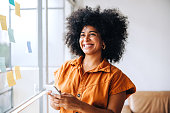 istock Happy black businesswoman using a smartphone in a creative office 1408041355