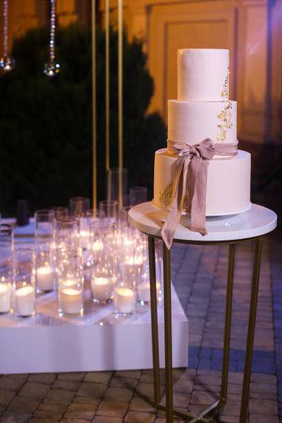 istock Multilevel wedding cake on the background of candles 1408042461