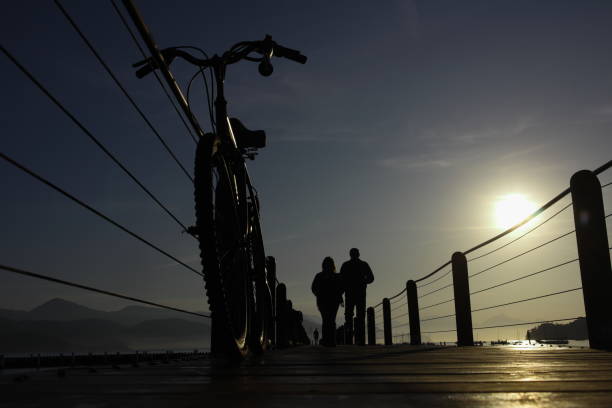 silhouette of a bicycle on a wooded bridge pier in the port during sunrise at ubatua, brazil - sao paulo south america marina southeastern region imagens e fotografias de stock