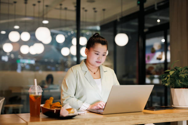 istock Overweight women working on laptops in restaurants 1408044597