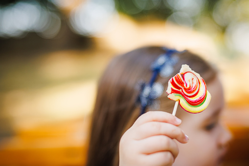 Half eaten lollipop in little girl's hand