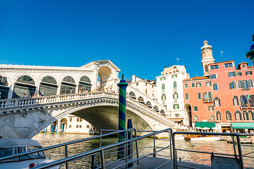 Panoramic view of Venice narrow canal with historical buildings from other gondola. Summer sunny day and sunset sky