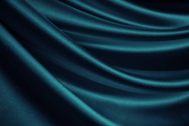blue green silk satin. soft wavy folds. shiny silky fabric. dark teal color elegant background with space for design. - satin blue dark textile imagens e fotografias de stock
