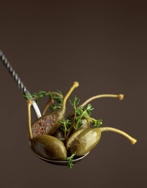 istock Large pickled capers with thyme on a brown background. 1408048589