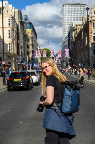바쁜 런던 스트리트의 금발 여성 사진 작가가 유니언 잭 깃발을 배경으로 - elizabeth i 뉴스 사진 이미지
