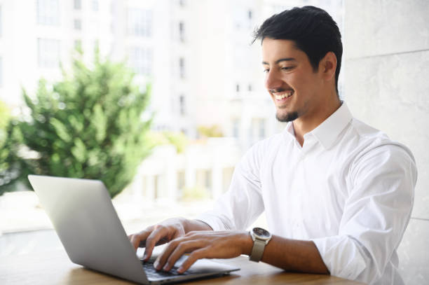 istock Handsome young businessman is using laptop outdoors 1408049651