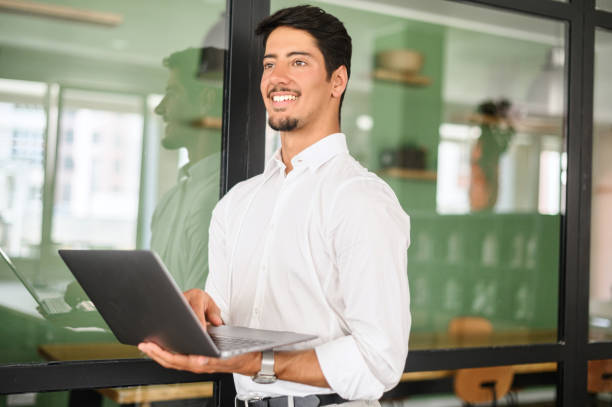 istock Smart and intelligent developer guy is working with laptop standing in contemporary coworking space 1408049717