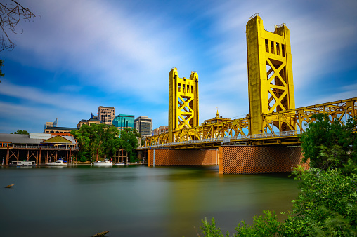 Gold Tower Bridge and Sacramento River in Sacramento, California, photographed from River Walk Park. Long exposure.