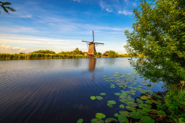 istock Historic windmill and a river flowing by in Kinderdijk, Netherlands 1408052145