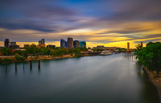 Colorful sunset above Sacramento skyline, Sacramento River and Tower Bridge in California. Long exposure.