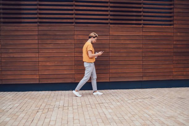 istock Man with cellphone moving on street 1408053451