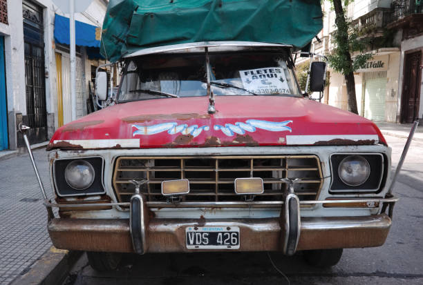 vista frontale del vecchio pick-up ford f-100 con cofano rosso, ruggine sul cofano e paraurti - pick up truck old car traffic foto e immagini stock