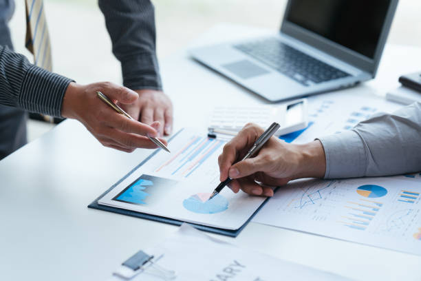 istock Group of business people meeting, discussing, analyzing graphs, financial data, and planning a marketing project together 1408054863