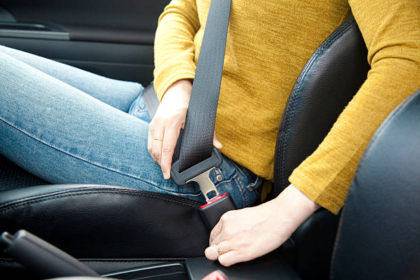 mano donna una cintura di fissaggio in auto - cintura di sicurezza foto e immagini stock
