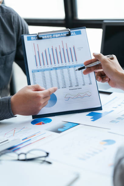 istock Group of business people meeting, discussing, analyzing graphs, financial data, and planning a marketing project together 1408055305
