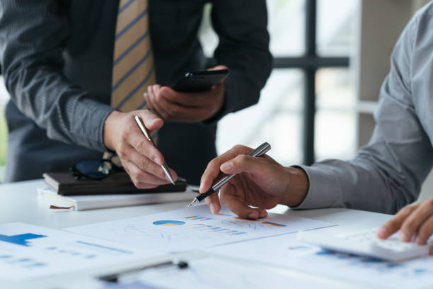 istock Group of business people meeting, discussing, analyzing graphs, financial data, and planning a marketing project together 1408056375