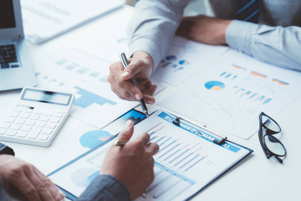 istock Group of business people meeting, discussing, analyzing graphs, financial data, and planning a marketing project together 1408056441