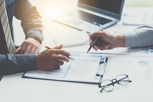 istock Group of business people meeting, discussing, analyzing graphs, financial data, and planning a marketing project together 1408057672
