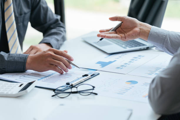 istock Group of business people meeting, discussing, analyzing graphs, financial data, and planning a marketing project together 1408057723