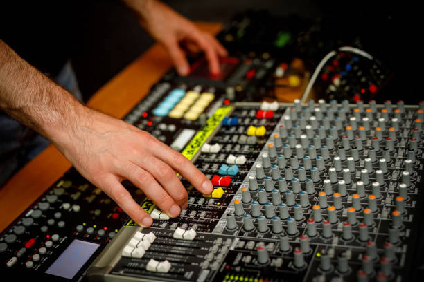 istock Hand of a sound engineer on sound console mixer. Equalizer control. 1408058715